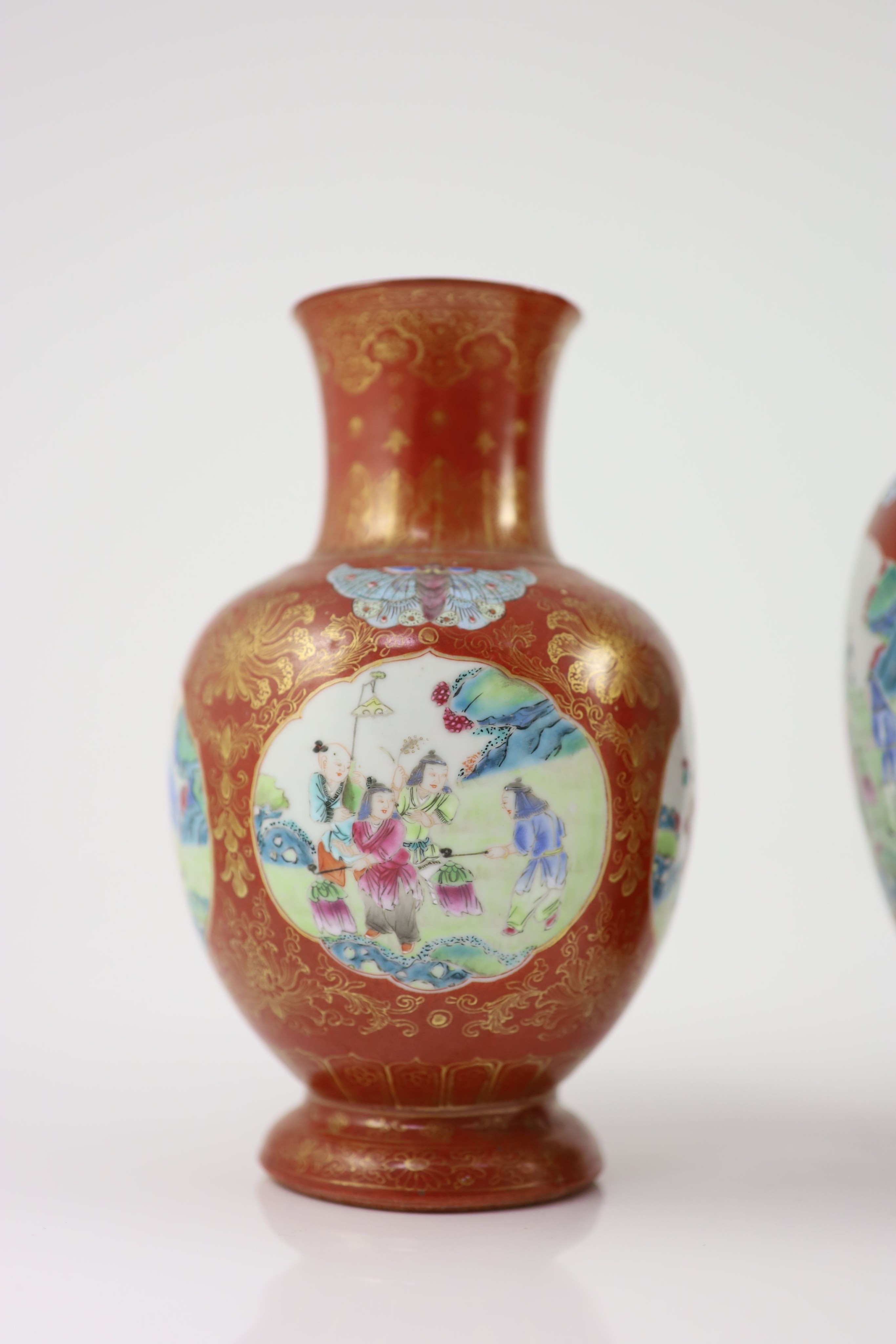 A set of three Chinese coral ground ‘boys’ vases, Jiaqing period (1796-1820), 19.5 and 23.5cm high